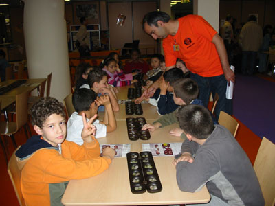 Guy Sepahi showing children how to play Awele