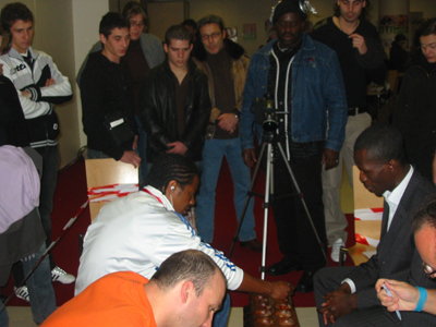 Fernando playing Benjin with Jeff & spectators looking on